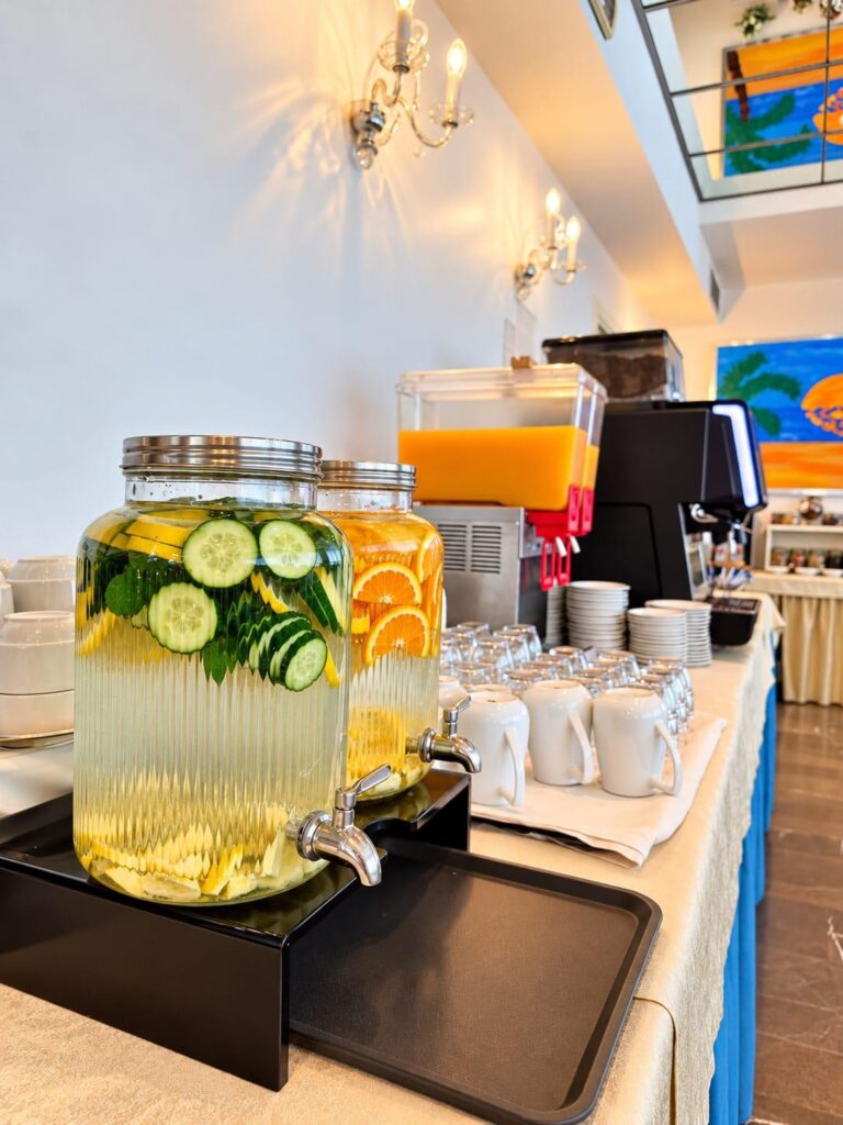Dispenser con acque aromatizzate e bevande nella sala colazioni del Club House Hotel
